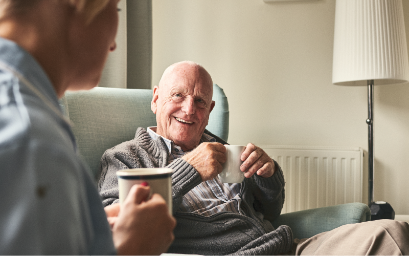 Person smiling with a mug of tea