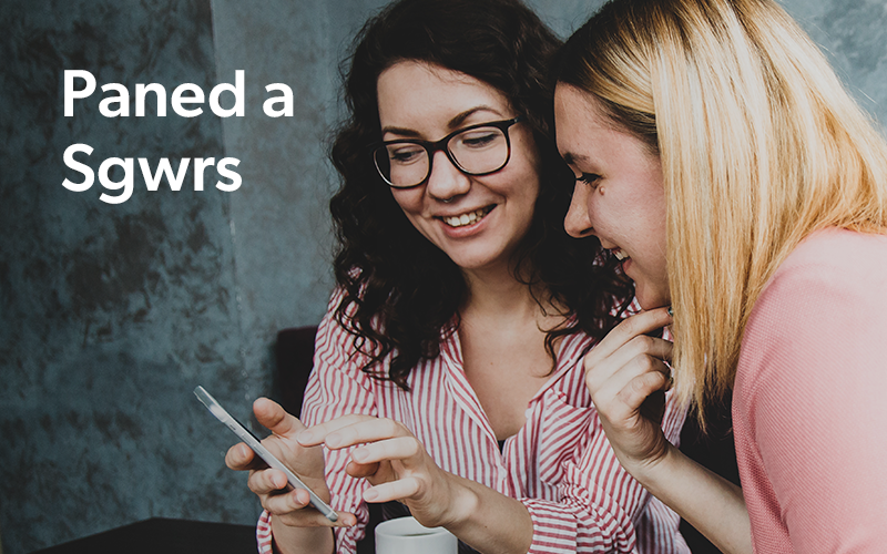 Picture depicting Paned a sgwrs - two women enjoying a conversation, looking at a phone and sharing a moment