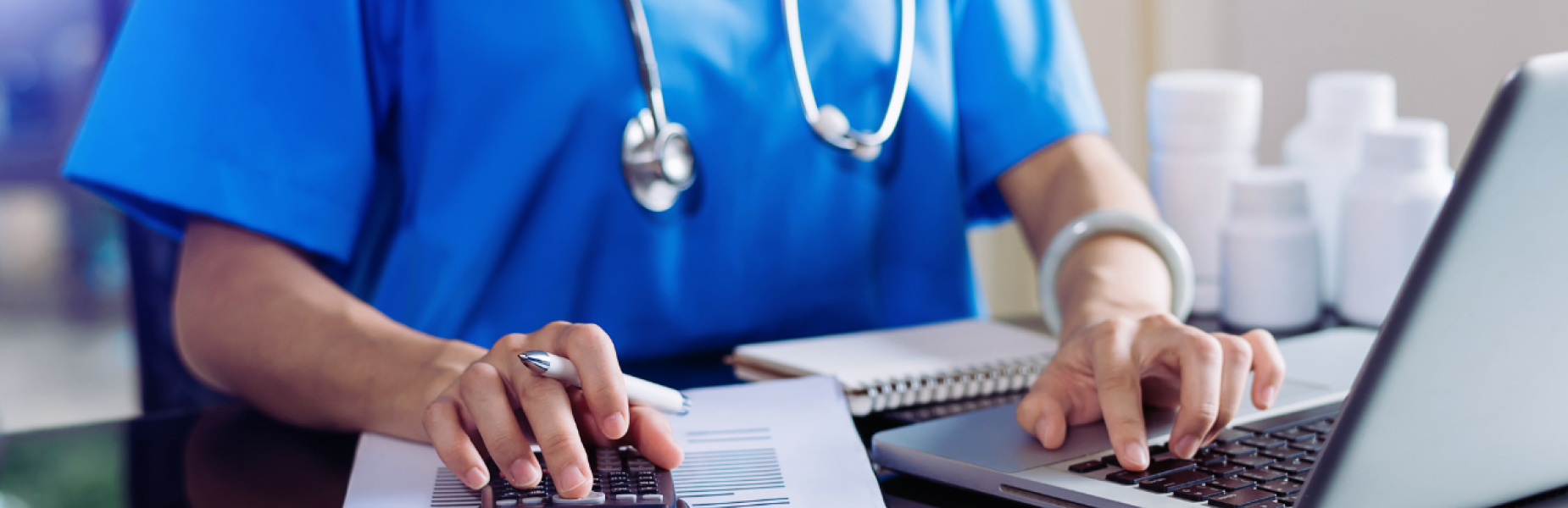 a doctor working at a laptop