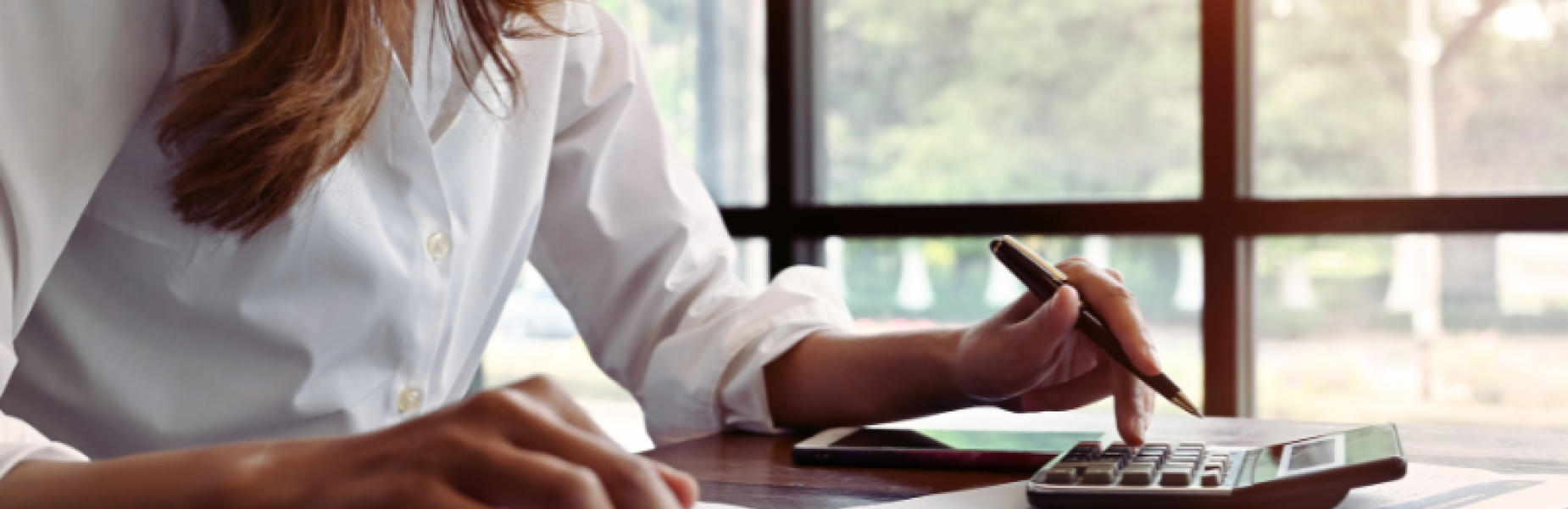 Woman working at a desk with a calculator