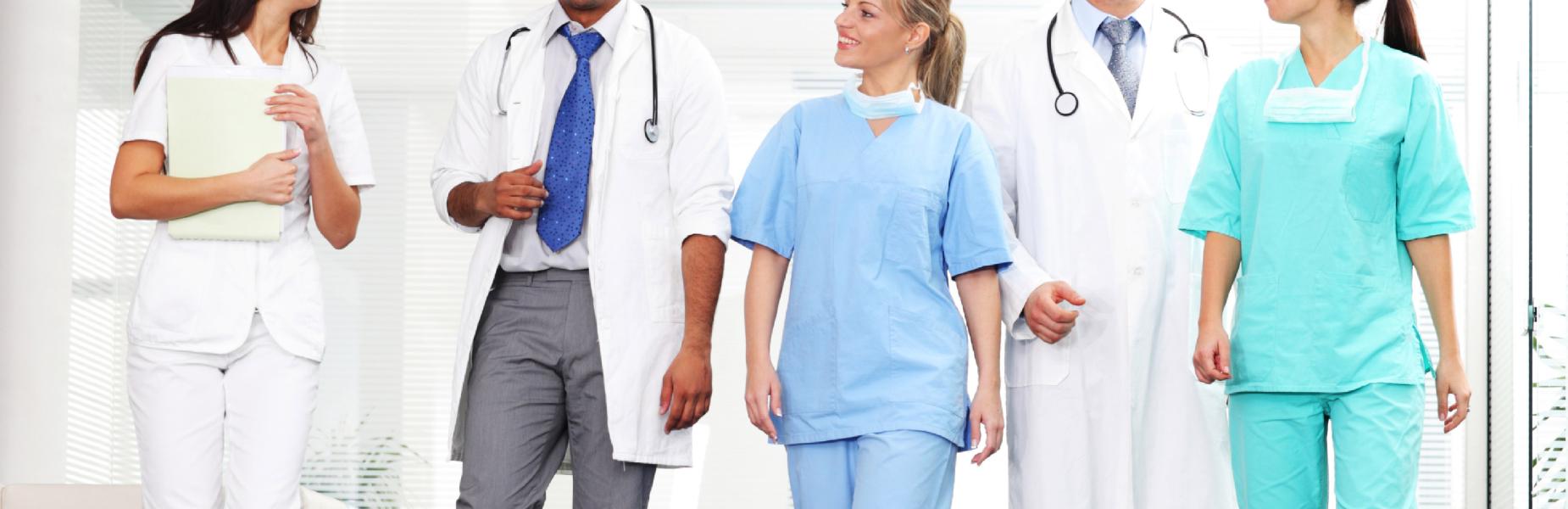 5 medical professionals walking and talking in a hospital