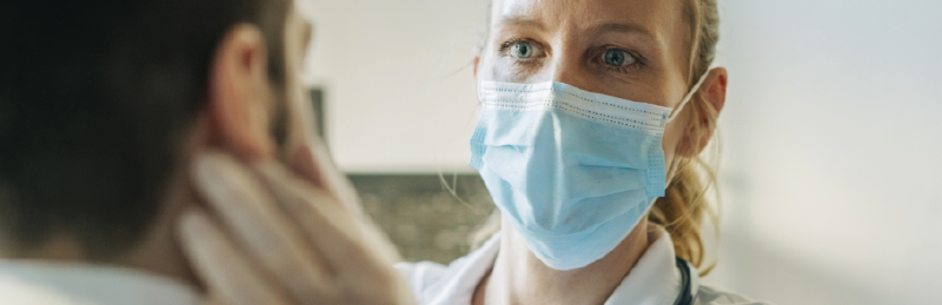 doctor wearing face shield looking at a patient